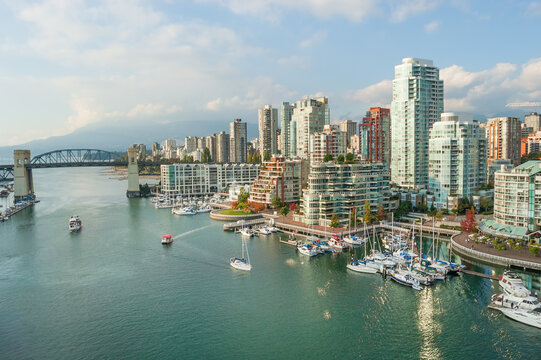 Burrard Street bridge crossing False Creek to the modern high-rise residential complexes and marina with The North Shore Mountains visible in the background, downtown Vancouver, Canada 