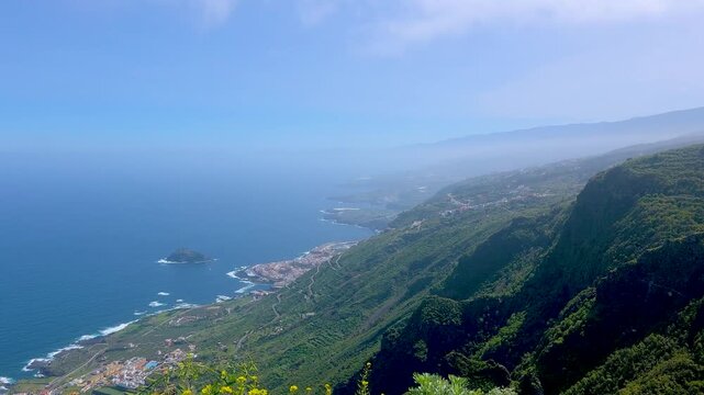 Sweeping views of Tenerife's rugged coastline at Punta de Teno, with lush greenery and expansive ocean. Ideal for travel ads and nature documentaries.