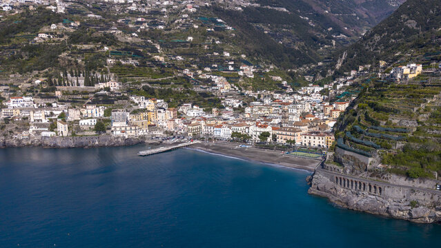 Aerial view of the coastal town clinging to steep slopes, where buildings meet the sea in a symphony of color and form, Minori, Salerno Italy