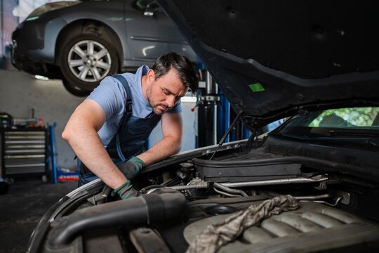 Mechanic repairing car engine in auto repair shop