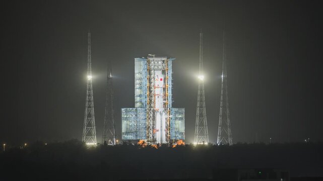 Night time-lapse of rocket launch pad & tower at Wenchang Space Launch Site, Hainan, China - Long March 7 launch preparation under industrial lights