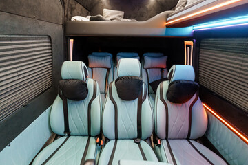 Naklejka premium Luxurious Camper Van Interior with Teal Leather Seats and Modern Ambient Lighting for Travel Lifestyle.