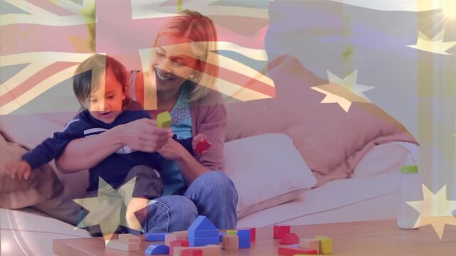 Composite video of waving australia flag against caucasian mother playing with her son at home