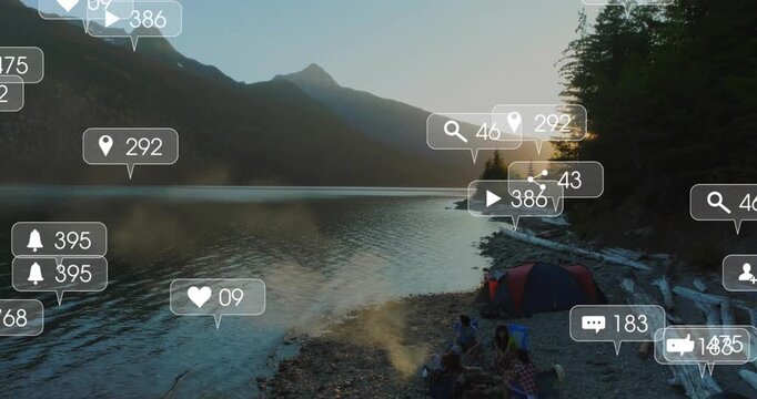 sun rising over peaks four campers sitting by campfire social media icons materializing on lake