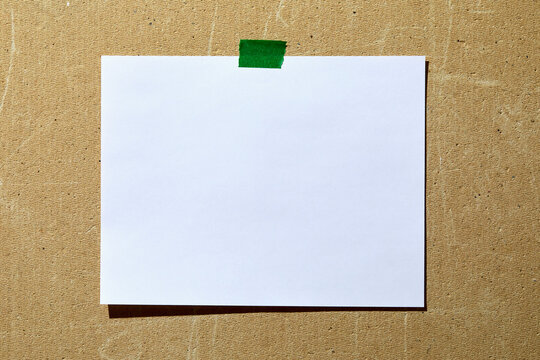 Blank paper taped to rough textured wall