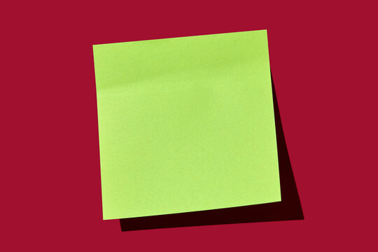 Blank green post it note on red background