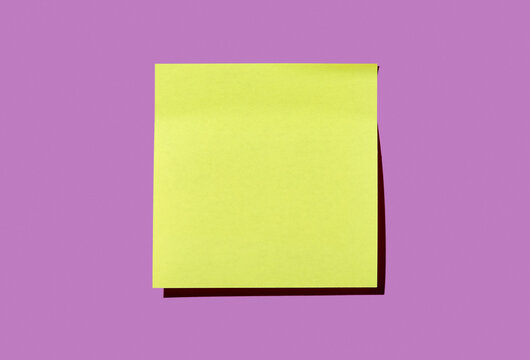 Blank yellow post it note on purple background