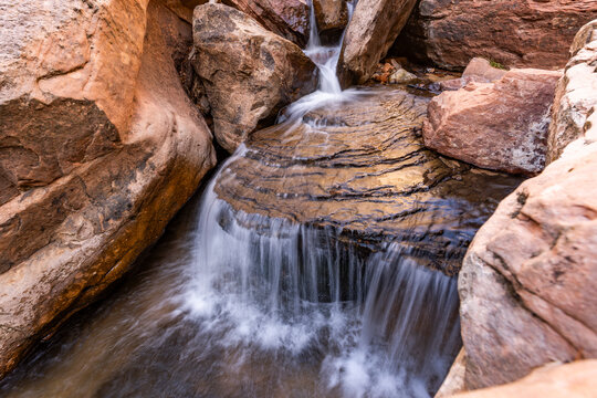Creek flowing on eroded rocks, blurred motion