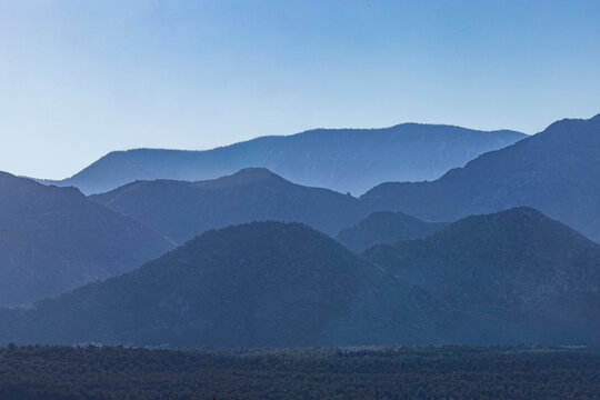 Silhouettes of mountain ranges against clear blue sky