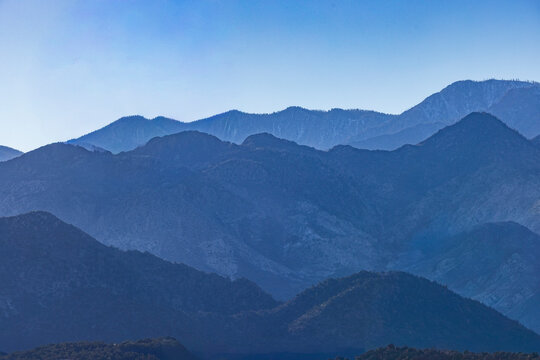 Silhouettes of mountain ranges against clear blue sky