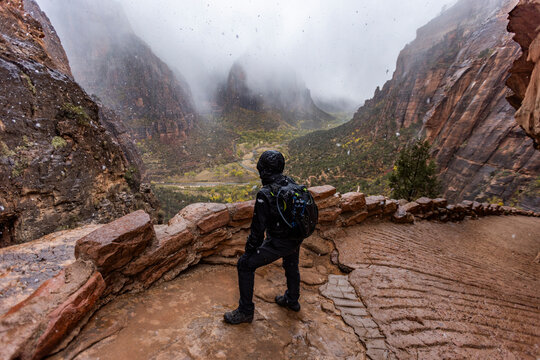 Rear view of female hiker in snowstorm on trail to Angels Landing