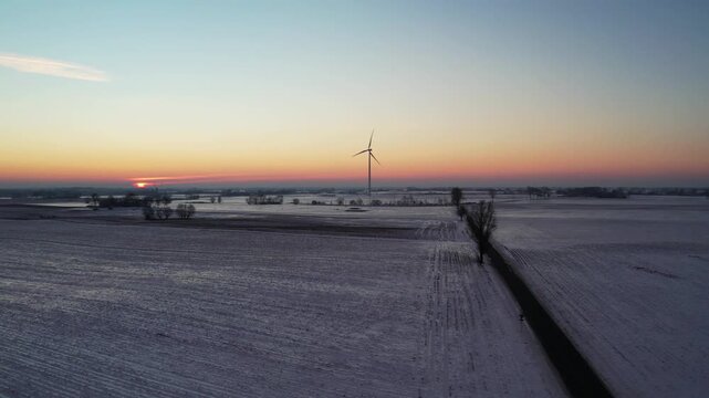 Sustainable energy in winter scenery &ndash; sunset over rural fields.