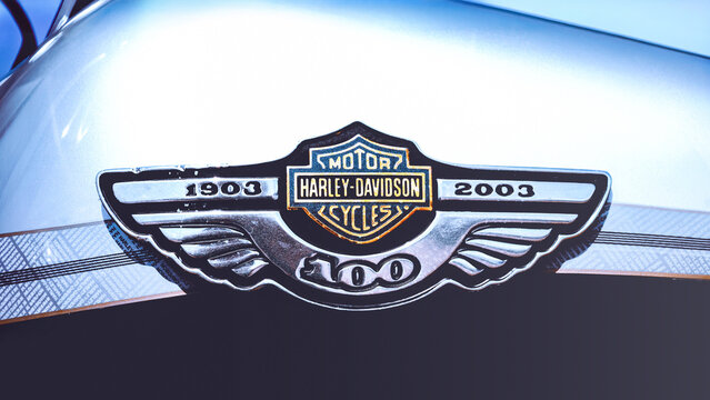 Poznan, Poland - April 2, 2026. Special 100th anniversary logo of Harley-Davidson Motorcycles on a fuel tank of a vintage chopper.