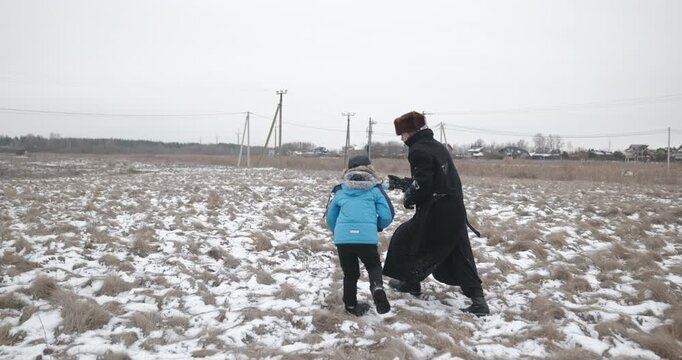 Man and kid boy go for walk. Dad and son play outside. 4K 10-bit