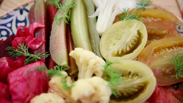 Colorful, traditional plate of pickled vegetables including tomatoes, cucumbers, cabbage, and cauliflower