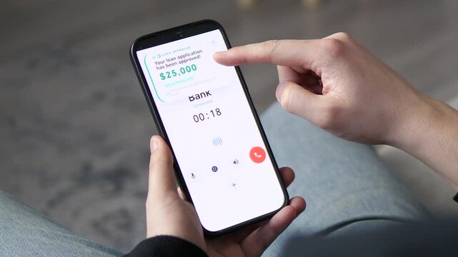 Close-up of a banking app on a phone showing a successful loan application message for 25,000 dollars. Real-time digital banking and credit approval process. Ideal for business, finance, and mobile