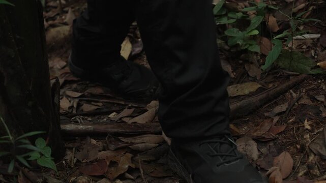 Low angle shot of rubber boots walking on muddy Amazon jungle path
