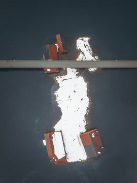 Aerial view of structures contrasting against the dark water, creating a stark visual interplay of light and shadow, Svolvaer, Nordland, Norway.