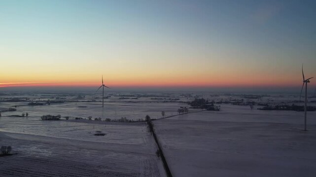 Sustainable energy in winter scenery &ndash; sunset over rural fields.