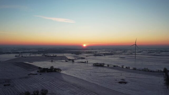 Sustainable energy in winter scenery &ndash; sunset over rural fields.