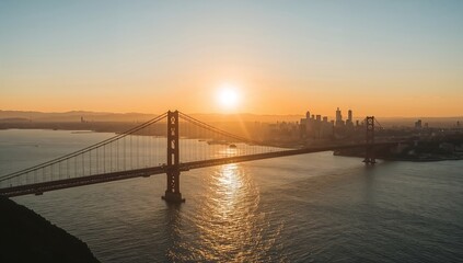 Obraz premium The majestic golden gate bridge under the sunset, with the sun's warm glow reflecting off the bay's surface, offers a stunning view. The skyline adds depth to this vibrant landscape