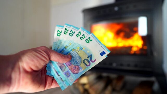Heating payment. Save money wood stove. Euro money banknotes for payment of heating firewood. Budget wood heat home. Euro money pay for heating costs in heating season. Heat house in European Union EU