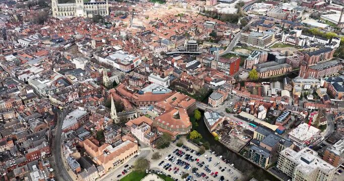 Aerial drone footage of the city of York in North Yorkshire UK with the Clifford Tower and circular structure grass mound surrounding roads and car park captured directly from above in the spring time
