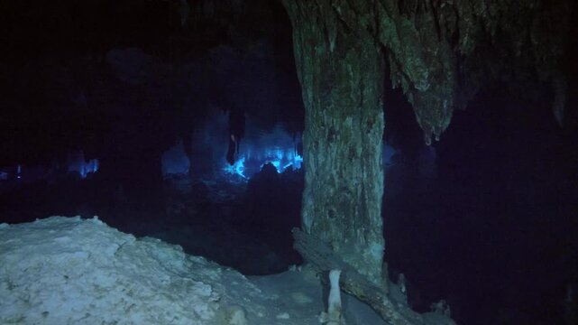 Focused light reveals calcite column structure and texture in dark cenote cavern in Cenote Dos Ojos, Quintana Roo, Mexico
