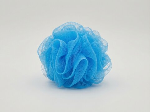 Blue mesh bath shower loofah sponge isolated on white background with soft texture detail for personal hygiene and skincare