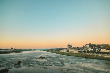 As the sun sets, gentle hues of orange and pink dance across the sky