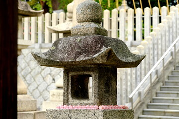 日本の神社に並ぶ可愛いピンクのうさぎと伝統的な石灯籠 © taka