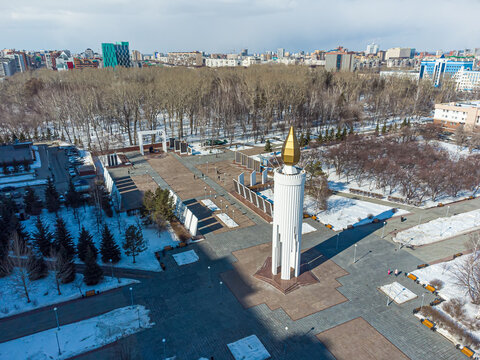 High-angle drone shot (top-down / bird's-eye view) of the central memorial stele known as the "Candle of Memory" (also referred to as the "Victory Memorial" or "Свеча Памяти") on Memory
