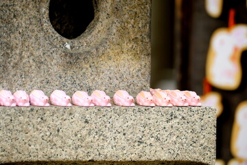 日本の神社に並ぶ可愛いピンクのうさぎと伝統的な石灯籠 © taka