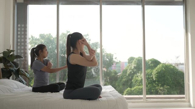 Two Asian women are exercising during morning time in the bedroom. Lifestyles, Health care.