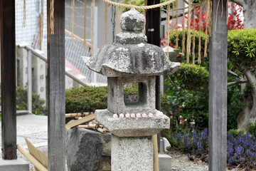日本の神社で見つける可愛いピンクのうさぎ守りと石灯籠の伝統風景 © taka