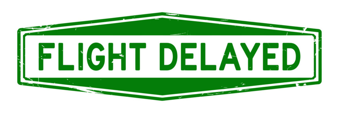 Green flight delayed sign with white text and border