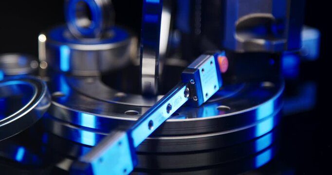 Close-up of a high-precision linear guide rail with miniature carriage and blue lighting on industrial components
