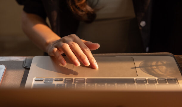 Hands typing on a laptop keyboard, focused on work in a modern setting.