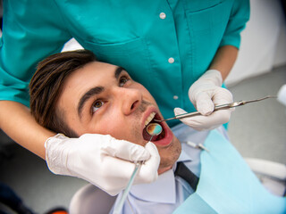 Man receiving dental checkup in clinic.
