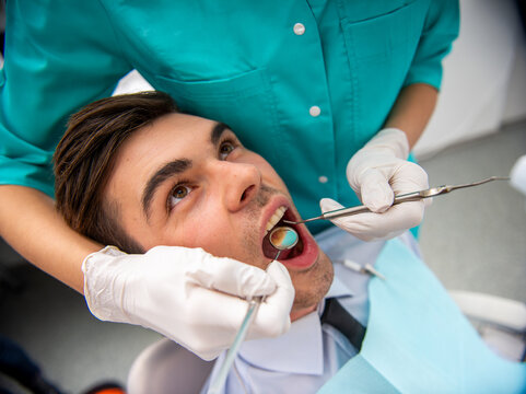 Man receiving dental checkup in clinic.