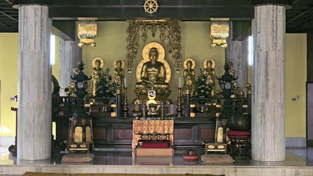 Interior of a Buddhist temple featuring a golden Buddha statue, colorful decorations, and prayer seating. Spiritual and peaceful ambiance ideal for religion, meditation, Bodh Gaya , Bihar, India