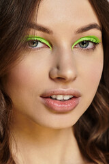 Naklejka premium Vibrant green eyeshadow enhances the allure of a young woman's bold makeup style