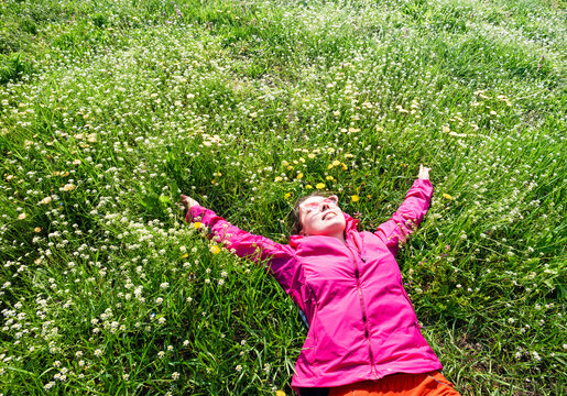 Woman relaxing on green grass enjoying spring nature