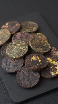 Organic Chinese green pu-erh tea with various herbs in round bricks. Chinese pu-erh tea as a background for your design
