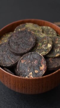 Organic Chinese green pu-erh tea with various herbs in round bricks. Chinese pu-erh tea as a background for your design