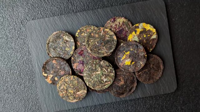Organic Chinese green pu-erh tea with various herbs in round bricks. Chinese pu-erh tea as a background for your design