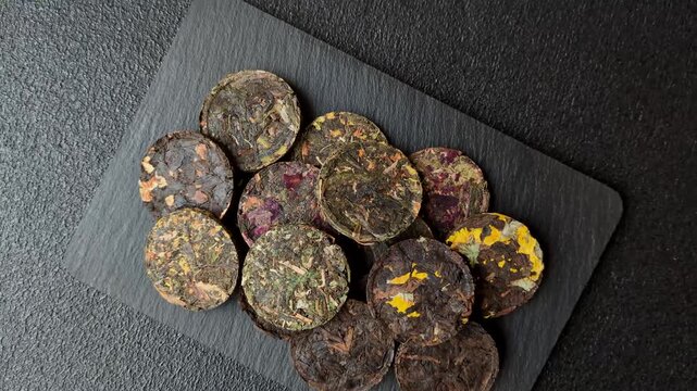Organic Chinese green pu-erh tea with various herbs in round bricks. Chinese pu-erh tea as a background for your design