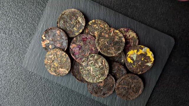 Organic Chinese green pu-erh tea with various herbs in round bricks. Chinese pu-erh tea as a background for your design