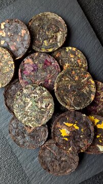 Organic Chinese green pu-erh tea with various herbs in round bricks. Chinese pu-erh tea as a background for your design