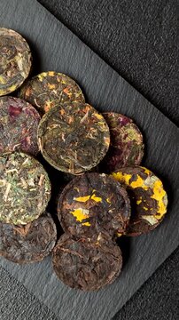 Organic Chinese green pu-erh tea with various herbs in round bricks. Chinese pu-erh tea as a background for your design